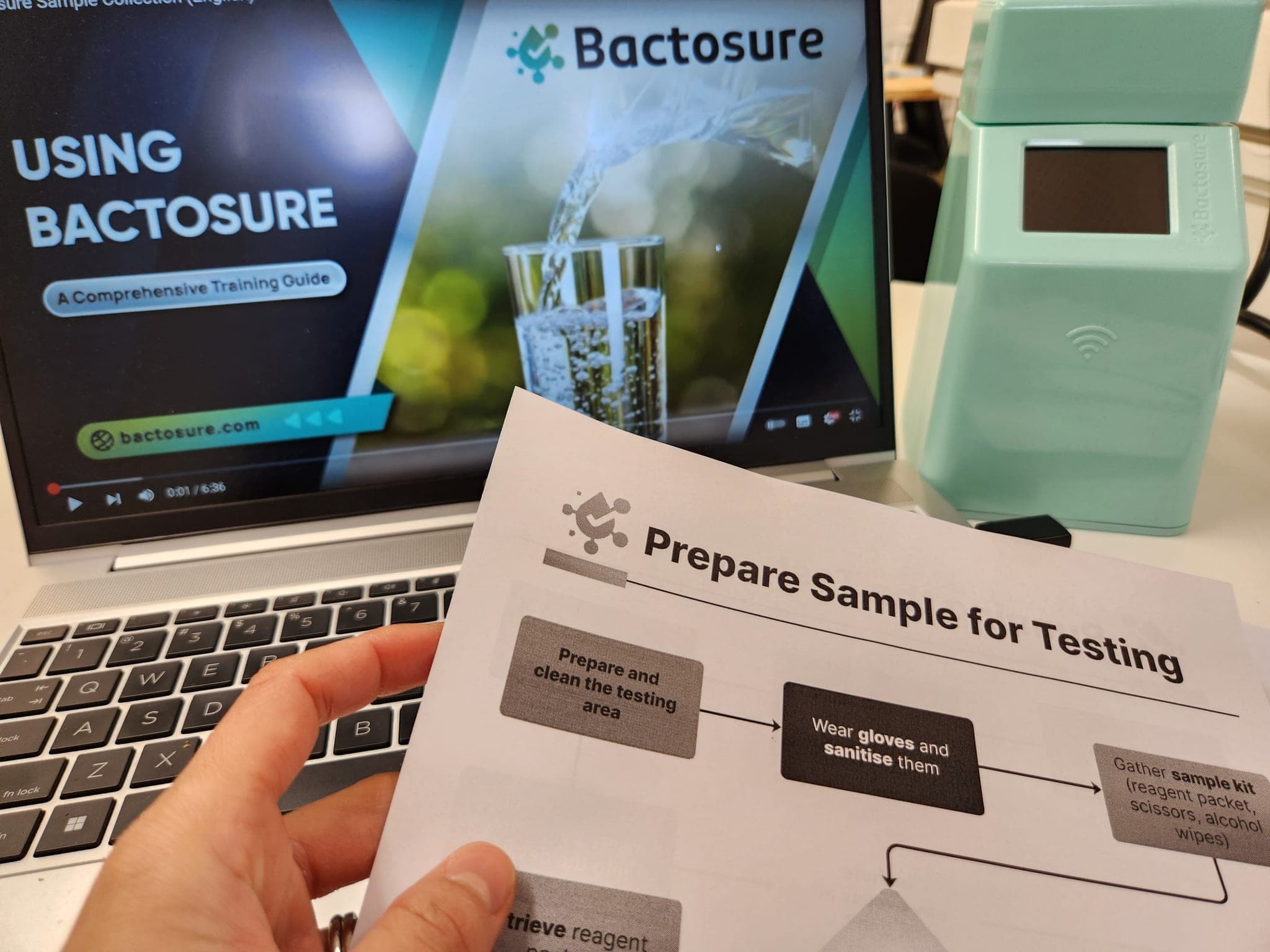 Bactosure training material and checklist displayed beside a device.
